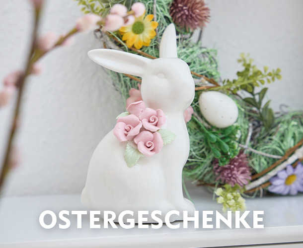 Keramikhase vor einem &ouml;sterlichen Deko-Kranz verlinkt auf die Kategorie Ostergeschenke